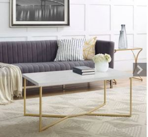 a rectangular white coffee table with gold metal legs