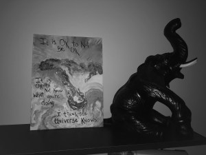 a black and white photo of a piece of handmade art from a friend propped next to an elephant