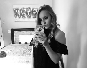 a black and white selfie of me with my hair curled wearing a black dress 