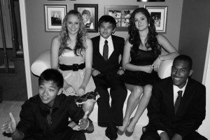 a black and white photo from homecoming in high school, I'm seated on a couch with two friends, two more friends are in front of u s