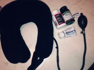 a large inflated neck support pillow and a handful of vitamins and creams 