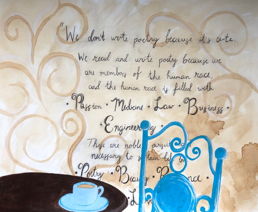 another coffee painting in a bistro with a painted blue chair and matching blue coffee cup with a walt whitman quote on the wall above 