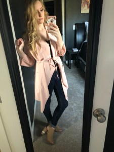 a selfie, i'm wearing a pink duster tied in the front with skinny jeans and nude heels. My blonde hair less vibrant and curled, my face rather expressionless.