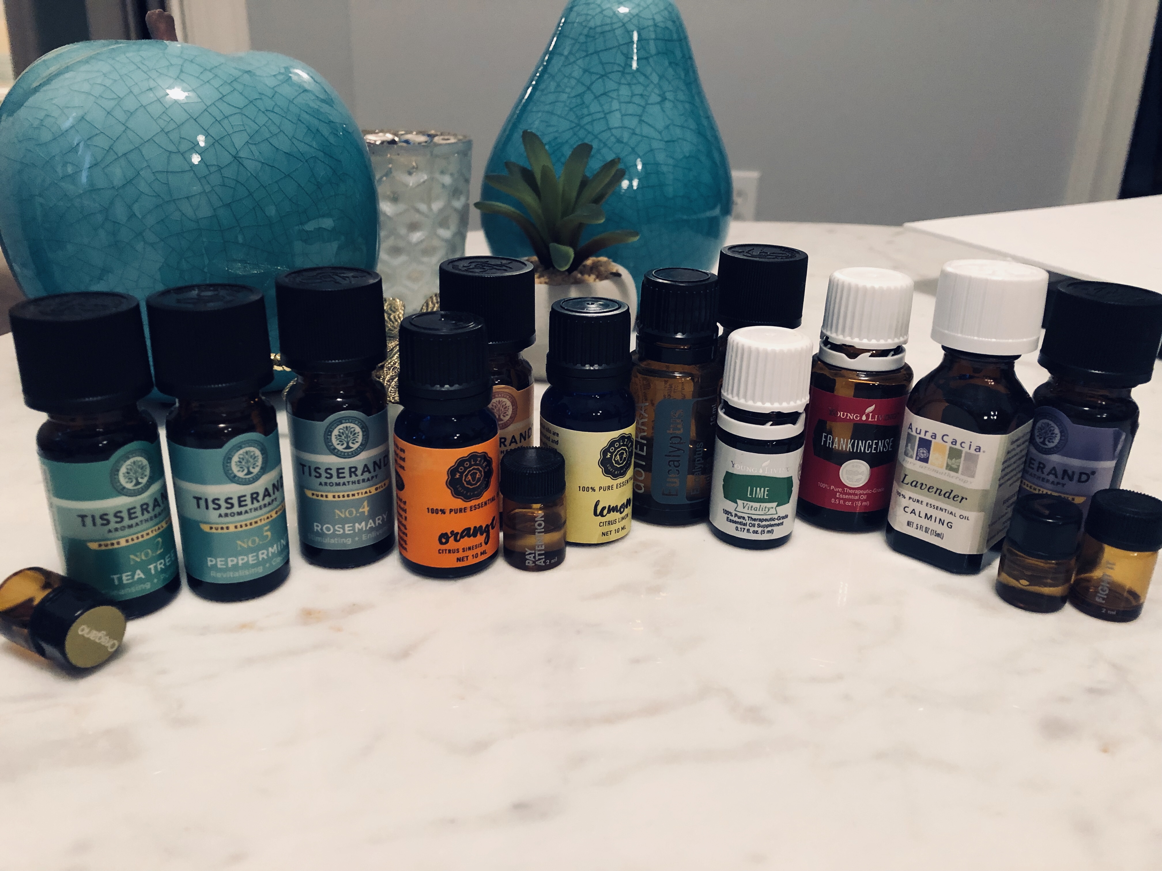 a photo of my collection of essential oils all lined up to demonstrate the variance of bottle types and brand varieties.