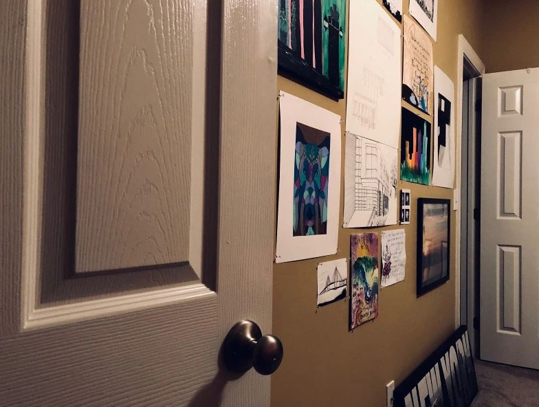 looking into a room from the doorway at the wall where artwork is extending across it