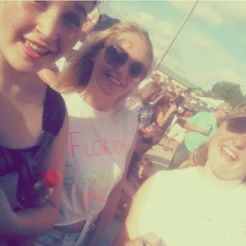 Three girls in a sunny concert venue with Florida Georgia Line shirts on. 