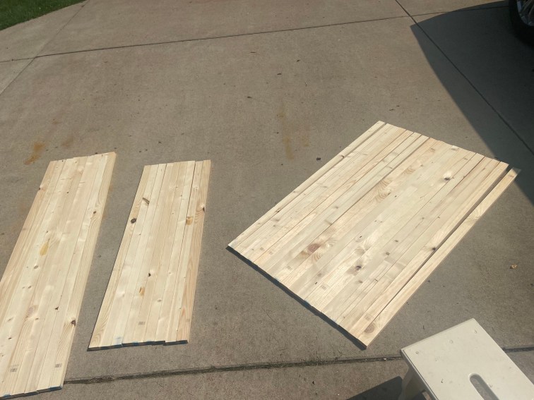 Three sections of 1 by 2 pine boards lay across my driveway sorted by height. The three groupings are respectively 4.5 feet tall, 3.5 feet tall, and the largest one being 4 feet tall boards.