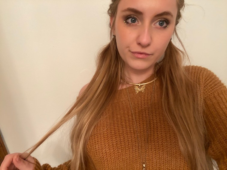 Me in a caramel colored sweater. My hair is parted down the middle with french braids going down to my ears and then the hair tied off to hang loose and long in low pigtails. 