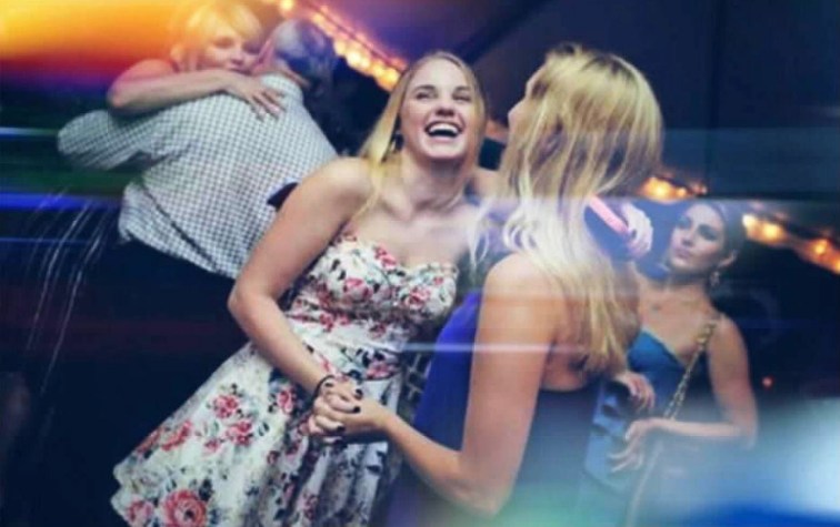 A photo from a wedding, the lights are down and I’m dancing in a blue dress with my back to the camera with one of my friends who is in a white dress her head tossed back laughing